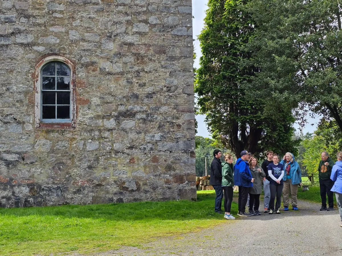 Visitors beside a stone building on a group trip