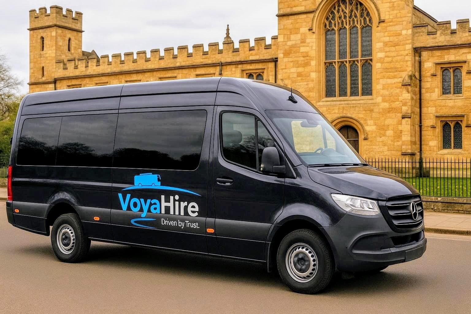 VoyaHire-branded minibus outside a historic stone building
